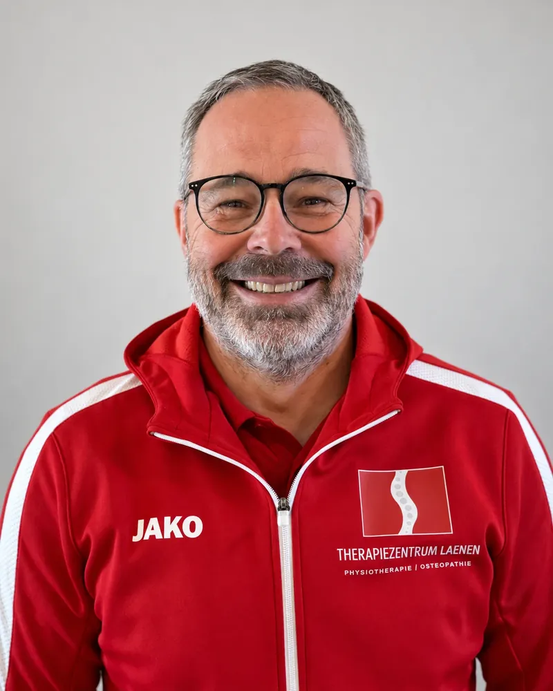 Porträt von Frank Laenen in roter Praxisjacke