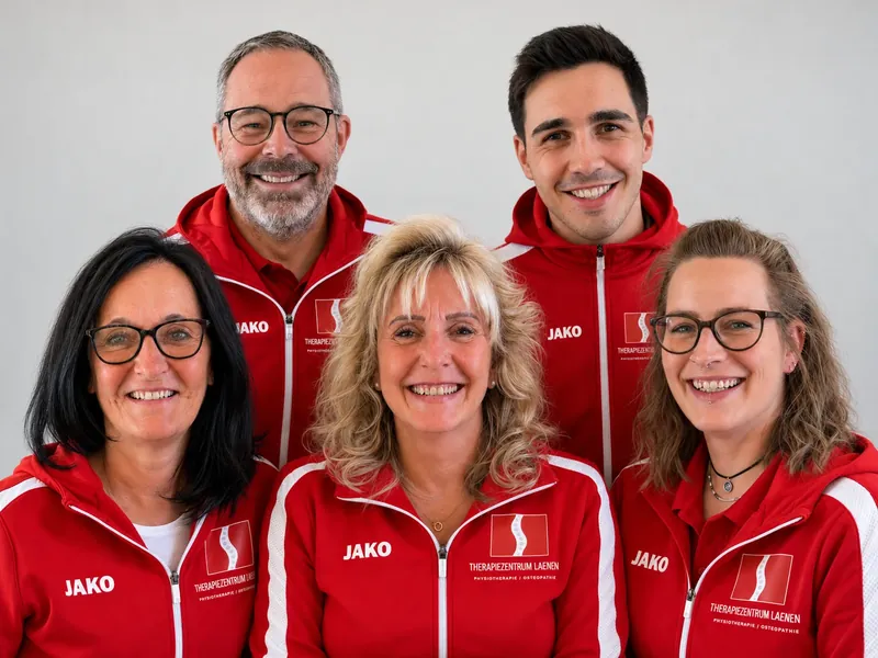 Das Team des Therapiezentrums Laenen in roten Praxisjacken